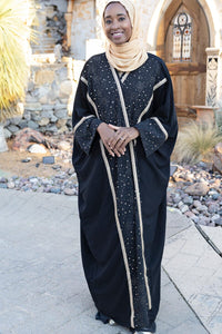 Celestial Mantle Cape Abaya – elegant black flowing abaya with cape-style sleeves, featuring subtle celestial-inspired embroidery.